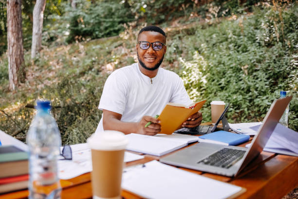 istock Black university student siting in public park and studying 1607945108