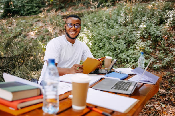 istock Black university student siting in public park and studying 1607945615