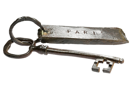 vintage hand-forged key with fob ‘PARIS’ isolated on white background
