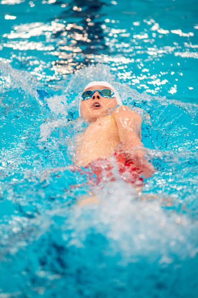 istock Swimmer boy swims backstroke swimming style in the pool 1607974820