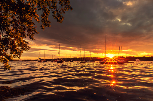 Picturesque sunset over a summer lake with sailboats, sky with clouds in the background, Poland