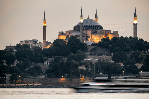 a boat passing in long exposure blurred in front of Hagia Sophia Istanbul Turkey