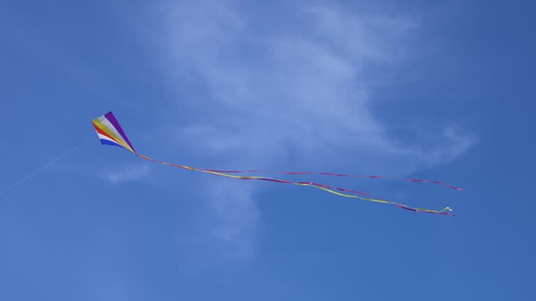 Flying kite against background blue sky with soft clouds at sunny day in summer