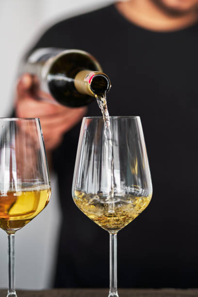 istock The bartender pours white wine into the glass. 1608012233