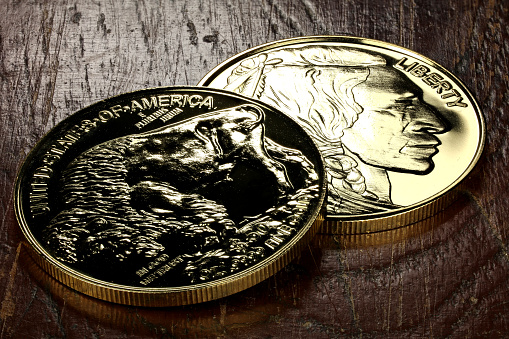 1 ounce American Buffalo gold bullion coins on wooden background