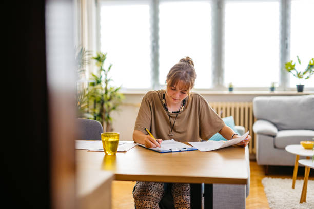 istock Young Woman Checking Her Finances At Home 1608041158