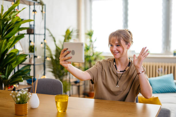 istock Cheerful Young Woman Having A Video Call On Tablet 1608041174