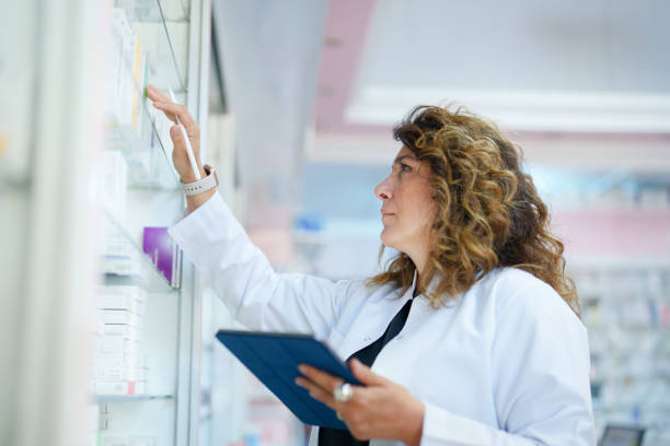 Pharmacist using a digital tablet to do inventory in a pharmacy Part of a series of a Day in the Life of Pharmacists at the Pharmacy drugs stock pictures, royalty-free photos & images