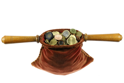 almsbag filled with Euro coins and some buttons isolated on white background