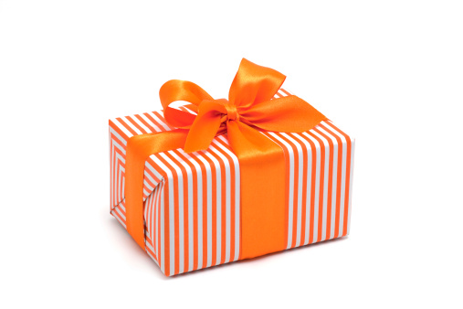 Gift box wrapped in orange stripped paper with an orange bow