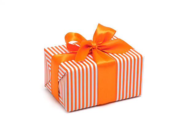 Gift box wrapped in orange stripped paper with an orange bow gift box with orange bow isolated on white wrapped stock pictures, royalty-free photos & images