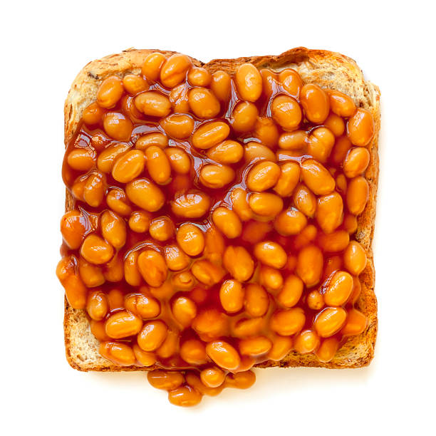 Baked Beans on Toast Isolated Baked beans on toast, isolated on white background.  Overhead view. baked beans stock pictures, royalty-free photos & images