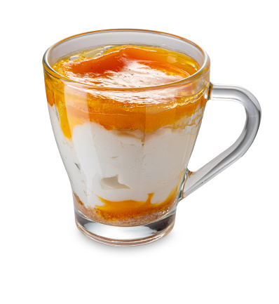 Ice cream semifreddo dessert with apricot flavored mousse in glass cup isolated on white with clipping path included