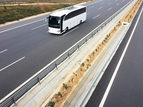 High angle view a white bus traveling on the highway with copy space. Bus on the asphalt road