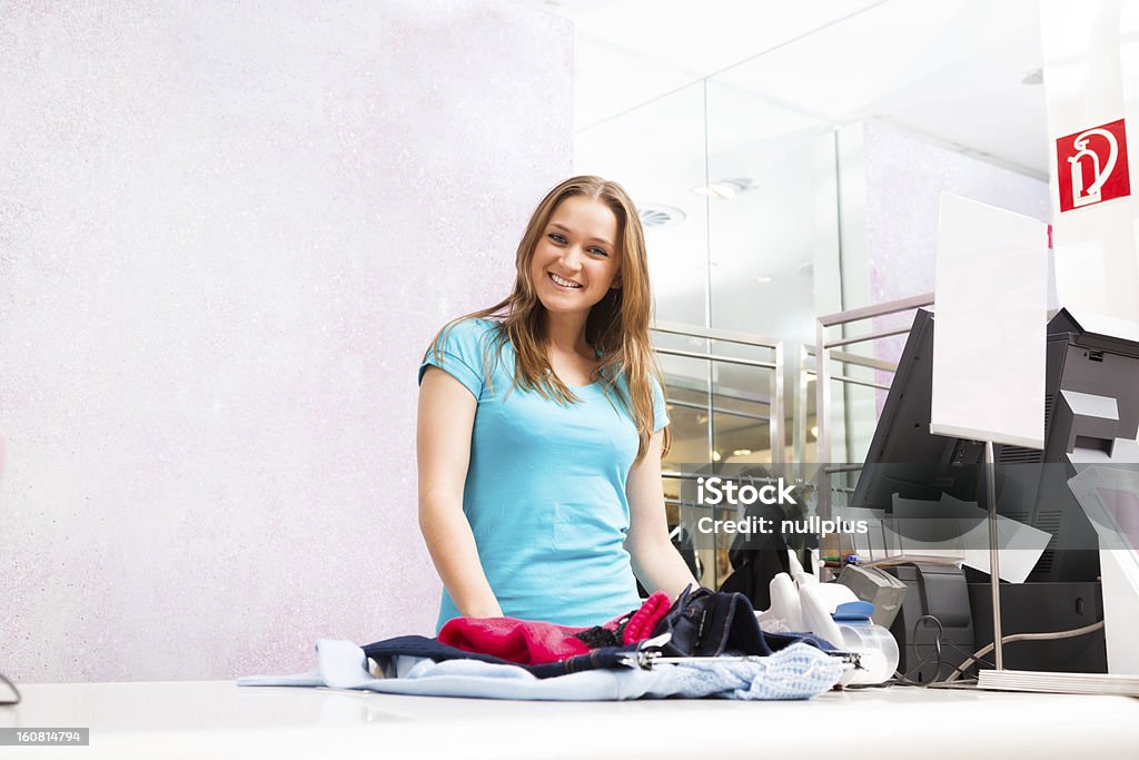 Venditore al registratore di cassa in piedi nel negozio di moda - Foto stock royalty-free di Abbigliamento