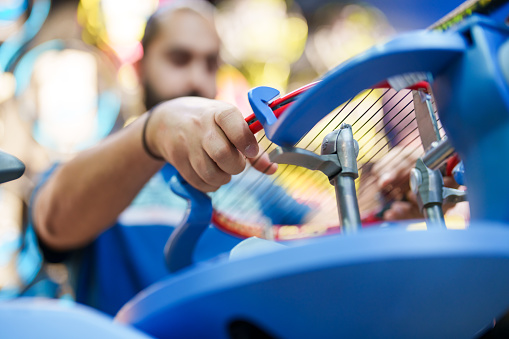 Close-up shot of hands stringing the racket on stringer
