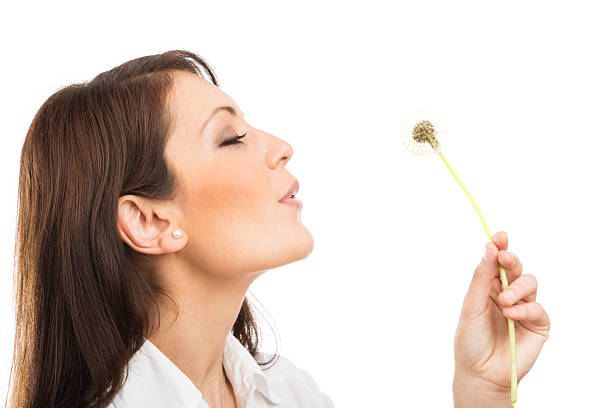 istock young woman wishing on a dandelion 160817040