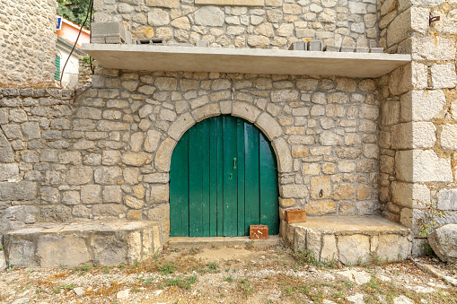 Old green door in a house of a village destroyed by an earthquake in Croatia