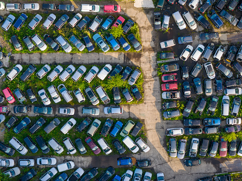 This aerial drone photo shows a car junkyard from above. The colourful cars which are being demolished are a fun background.