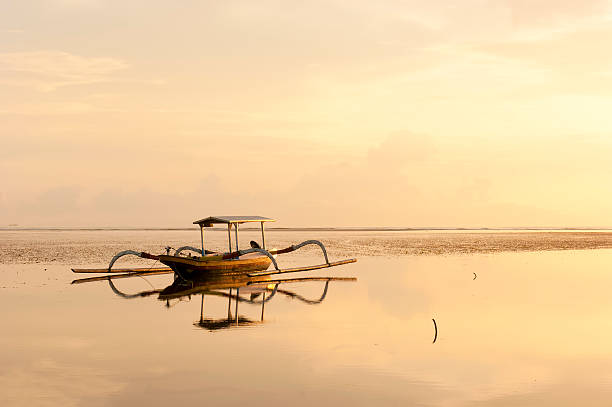 jukung, balinés barco la pesca tradicional en la playa al atardecer - jukung fotografías e imágenes de stock