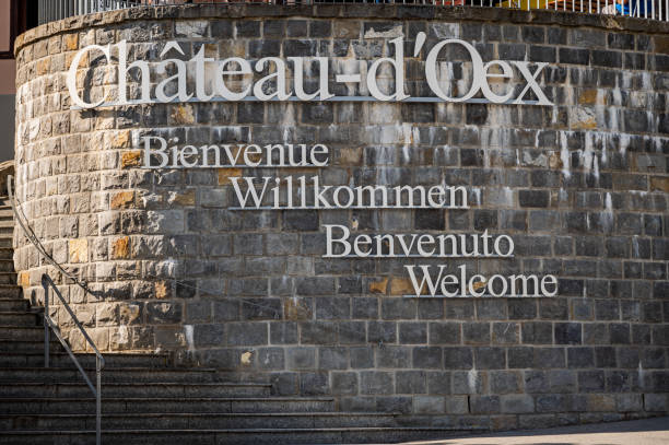 bienvenue à l’enseigne du château-d’oex. messages de bienvenue en français, anglais, allemand et italien sur le mur. - chateau doex photos et images de collection