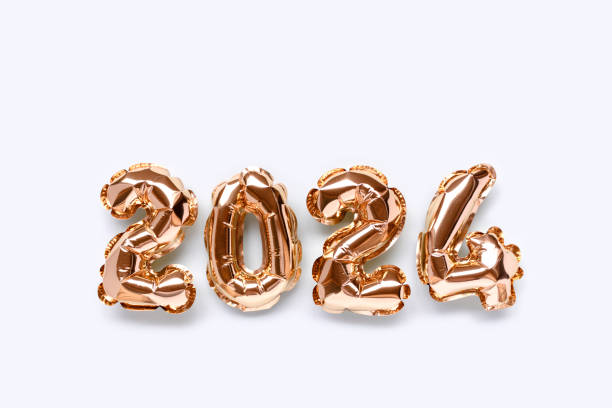 2024 golden inflatable balloons on a blue background with copy space.