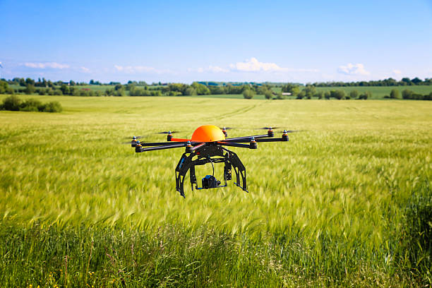 istock Flying octocopter drone against a green grassy sunny field 160826408