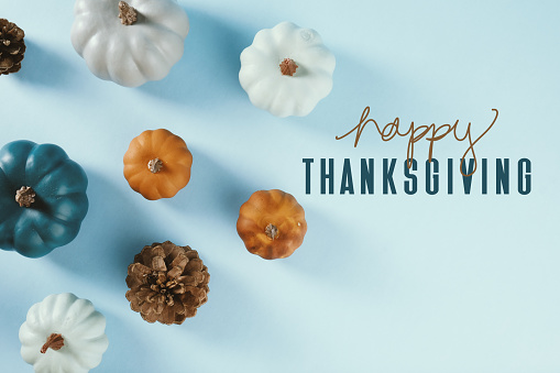 happy thanksgiving day conceptual image flat lay with pumpkins on blue background