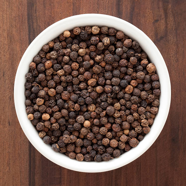 Black peppercorns Top view of white bowl full of black peppercorns black peppercorn photos stock pictures, royalty-free photos & images