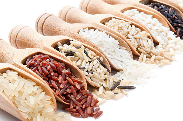 деревянные углубляется с различными типами риса из них отдельные - brown rice basmati rice rice cereal стоковые фото и изображения