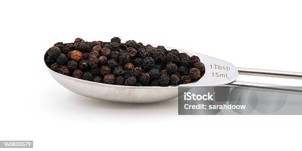 Negro Peppercorns Mide En Una Cucharada De Metal Foto de stock y más banco de imágenes de Alimento - Alimento, Comidas y bebidas, Condimento