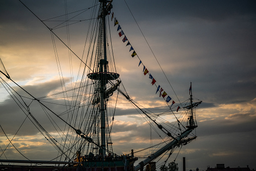 Masts of old ship against sunset clouds