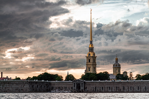 Peter and Paul Fortress seen from Neva river. Dramatic clouds and sky at sunset on the background. St. Petersburg