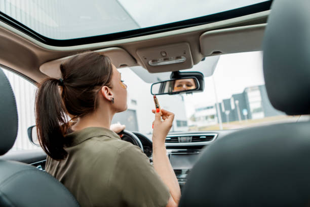 istock Distracted female driver doing her make-up at the wheel 1608313333