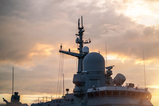 Military aircraft before take-off from aircraft carrier on sunset background