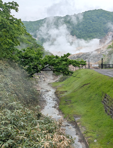 A steam leads away from Jigokudami, Hell Valley, in Noboribetsu Onsen. Spring morning in a volcanic landscape.