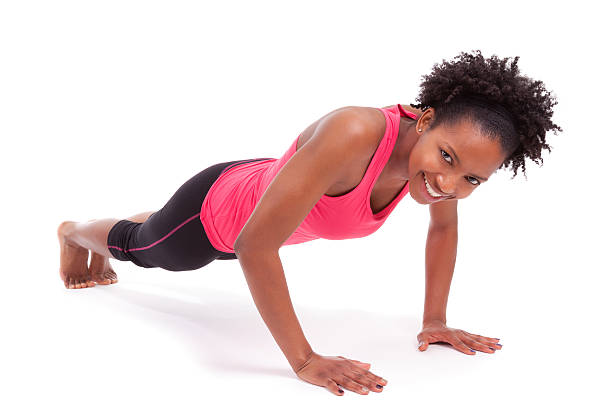 Young beautiful african fitness woman doing push up exercises on stock photo