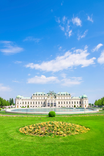 Beautiful summer view of classical Belvedere palace building with fountains in Vienna, Austria. Fantastic cloudscape with blue sky over the royal garden with flowers and trees. 