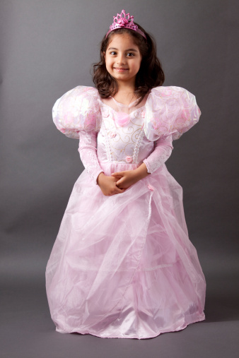 A beautiful girl child smiles as she dresses in her princess costume