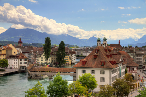 HDR image of the view over Luzern, Switserland. The natural museum and spreuerbrucke can be seen and the mountains in the background