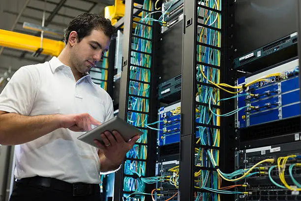 Photo of IT technician with network equipment and cables