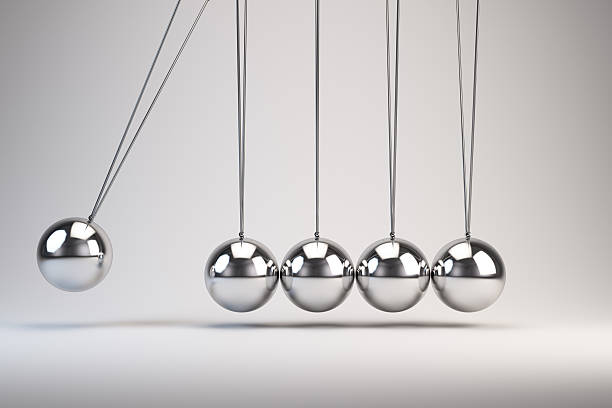 Silver balls of Newton's cradle swing back and forth Balancing balls Newton's cradle desk toy stock pictures, royalty-free photos & images