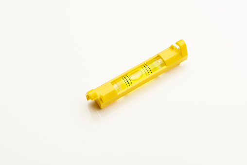 View of yellow color bubble level used in construction over white background