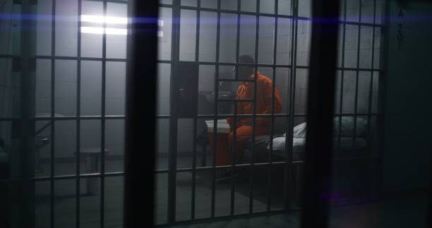istock African American prisoner sits on the bed, reads Bible 1608543229