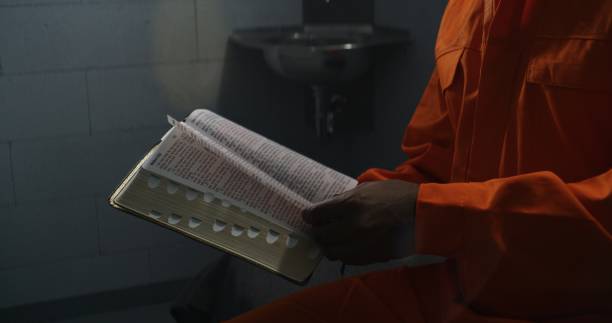istock African American prisoner reads Bible, turns pages 1608546015