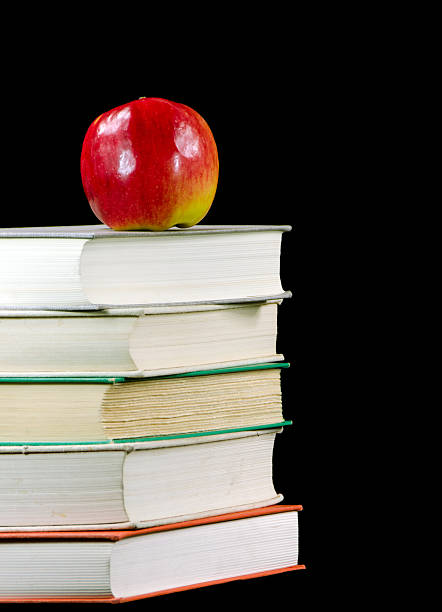 istock Stack of Old Books and Apple on Black 160857929