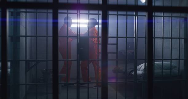 istock Prisoners in orange uniforms emotionally talk 1608584853