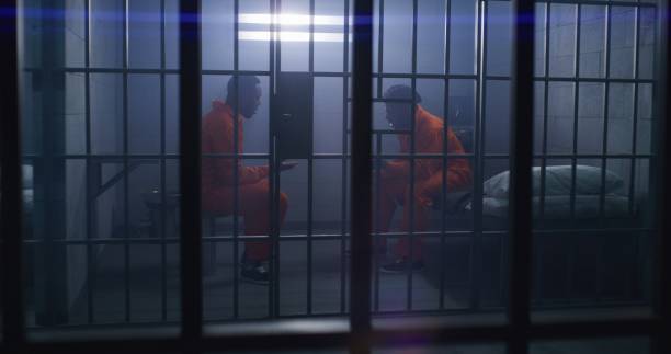 istock Prisoners in orange uniforms emotionally talk 1608585875
