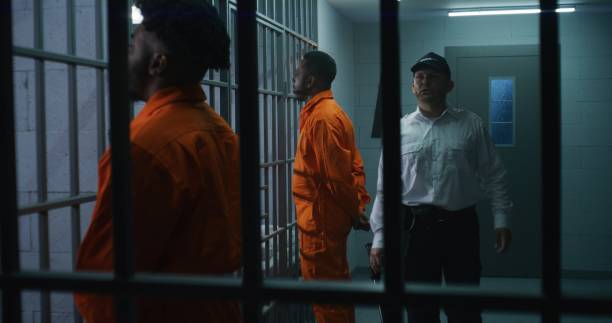 istock Criminals stand face to cell with hands behind 1608595426