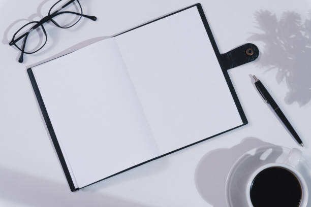 istock Notebook mockup on white office desk with a cup of coffee 1608598766